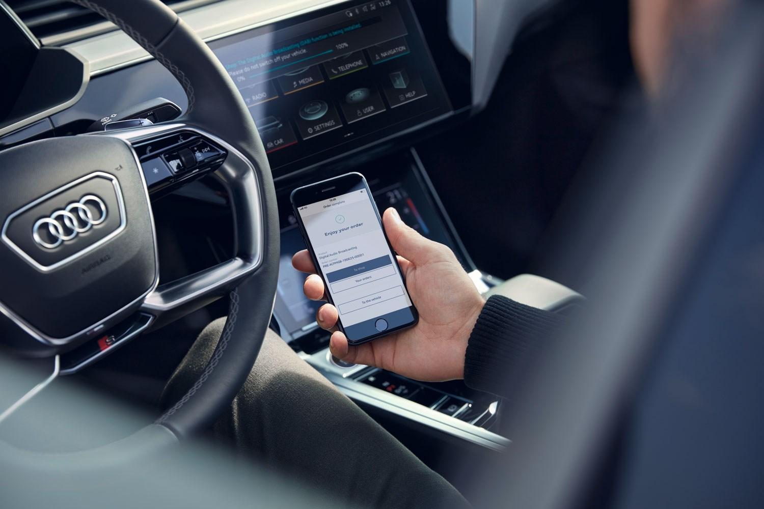 Image of customer with Audi connect app inside an Audi vehicle.