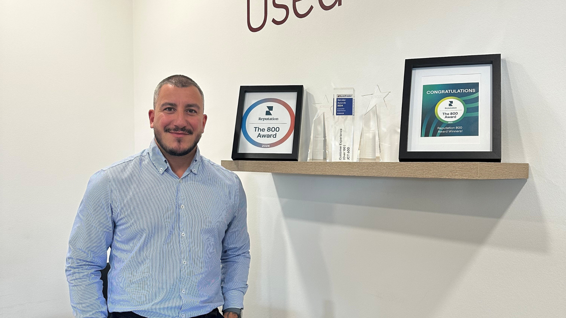 JCT600 Approved Doncaster team member stood in front of awards.