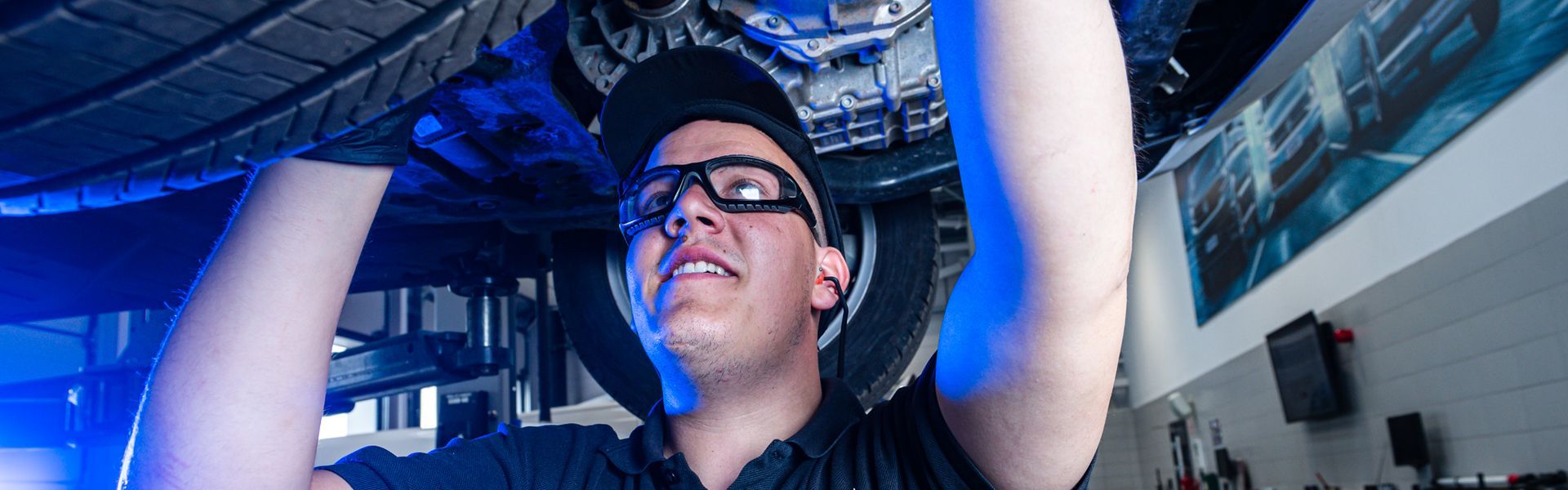 Volkswagen Technician inspects the underbody of van during routine maintenance