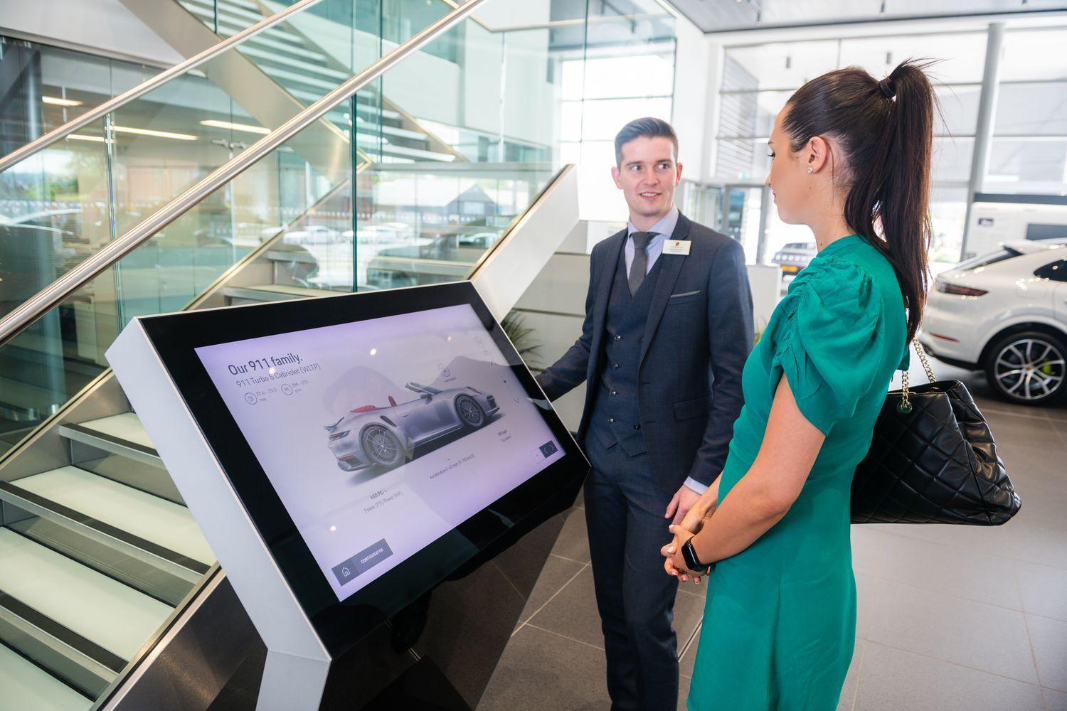 Porsche Finance Specialist talks to customer about the different finance options available for the newest Porsche Taycan.