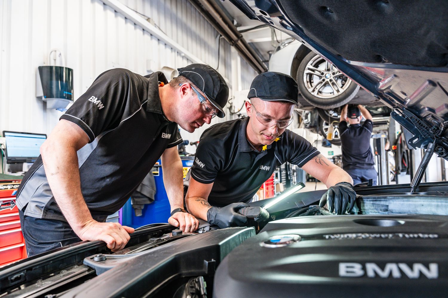 BMW Technicians inspect vehicle during service