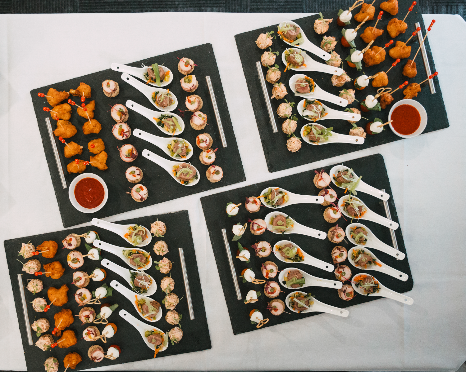 canapes laid out on slate platters and white tablecloth