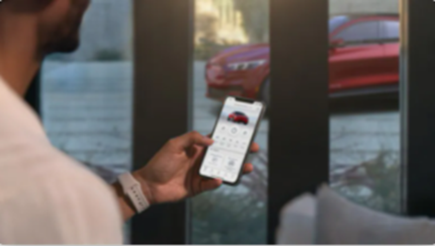 Man holding phone with FordPass app on 