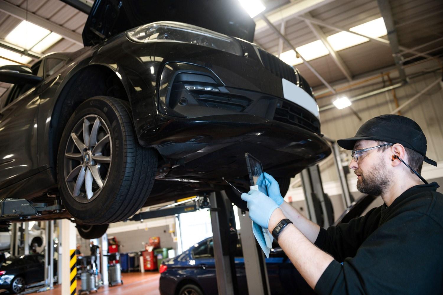 BMW Technician takes photo of tyre ahead of BMW vehicle repair at the BMW Repair Centre at Bavarian BMW Belfast