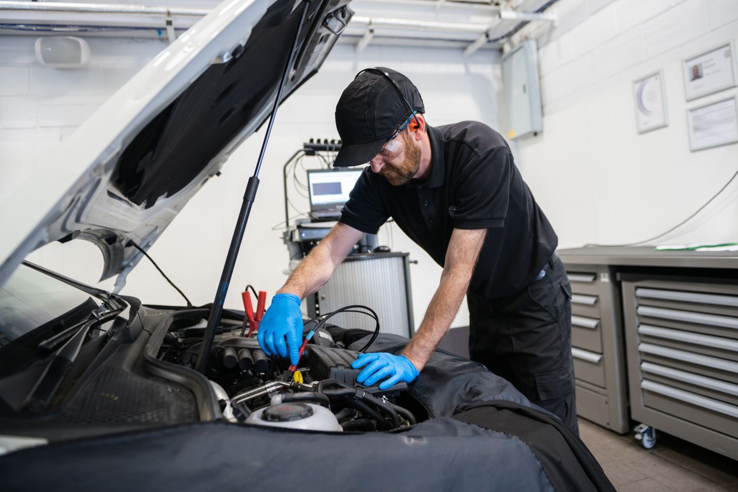 Volkswagen Technician inspects engine under the hood of vehicle during repair at Agnew Volkswagen Belfast