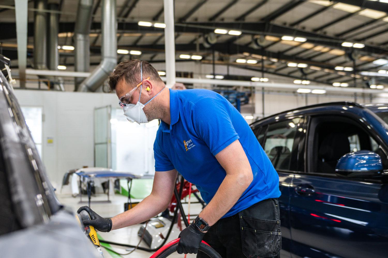 Agnew Repair Centre Specialist sands down car door ahead of body repair and paint