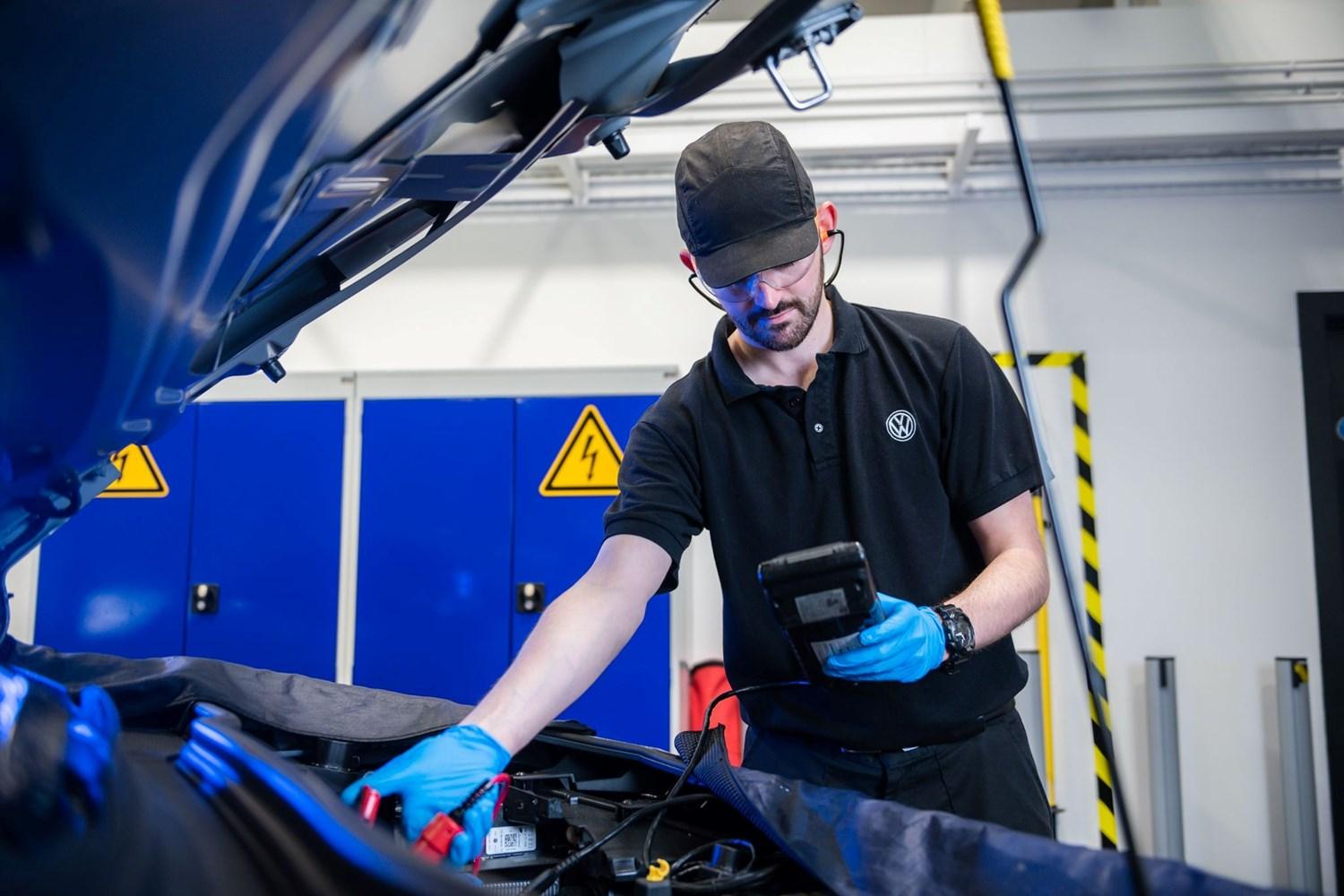 Volkswagen Service Specialist inspects Volkswagen Golf battery during pre-MOT inspection at the Volkswagen Approved Accident Repair Centre, Agnew Volkswagen Mallusk