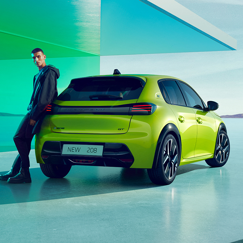 man standing by Peugeot 208