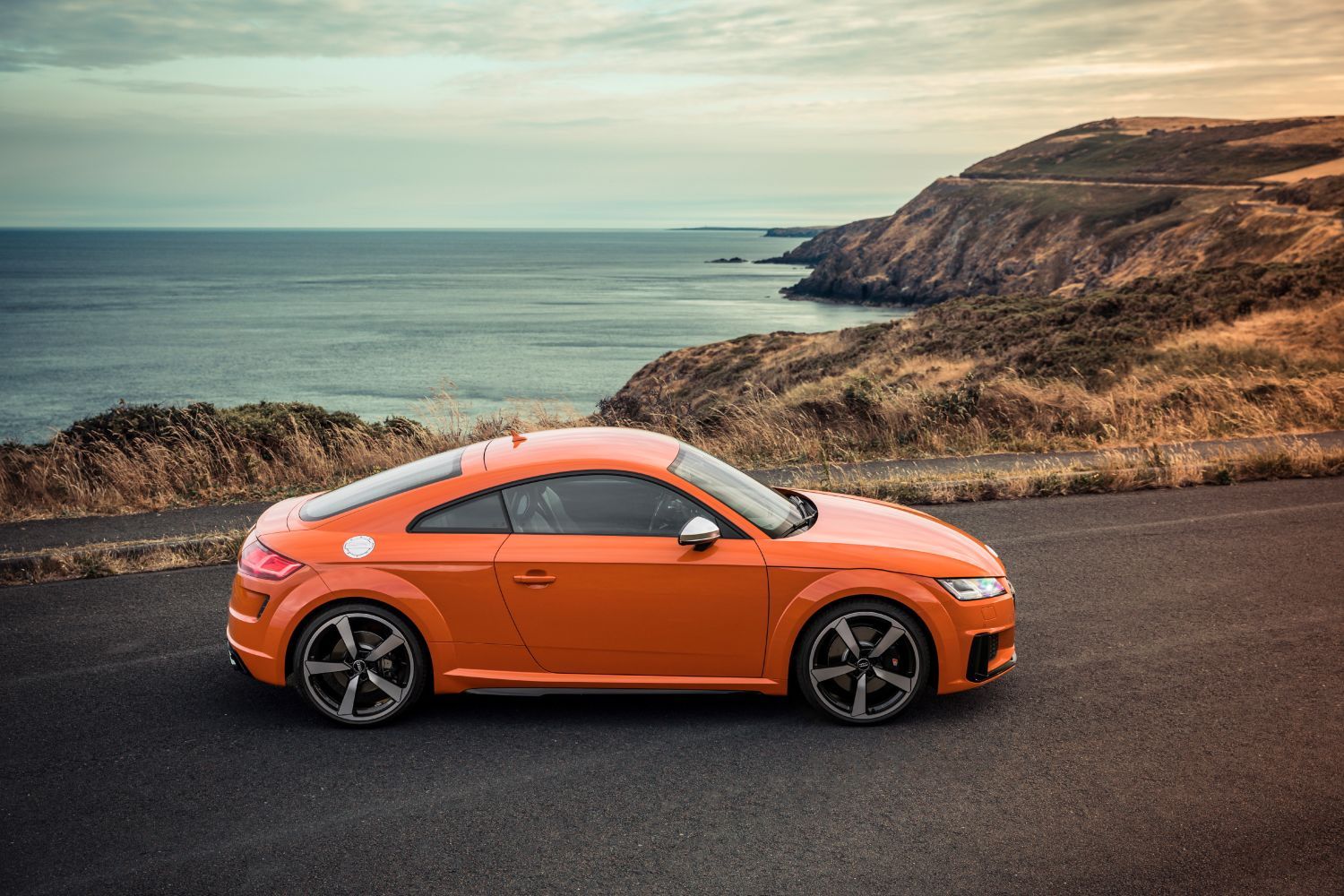 New Audi TTS Coupe in orange, side view image of vehicle