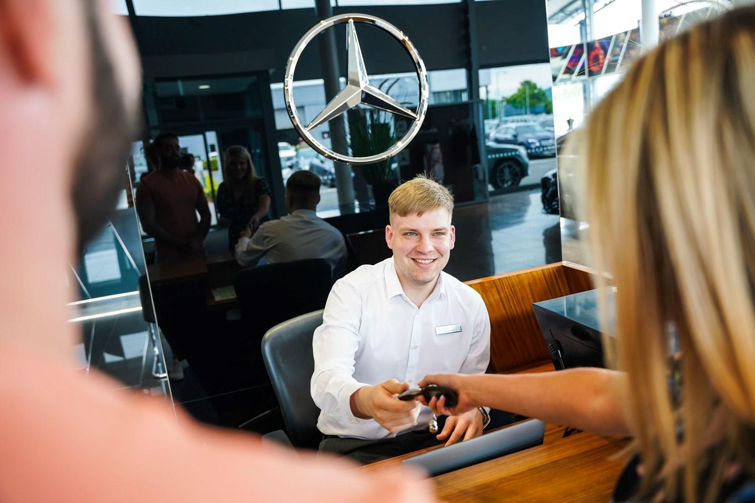 Mercedes-Benz Customer Service Specialist hands over Mercedes-Benz keys to customer
