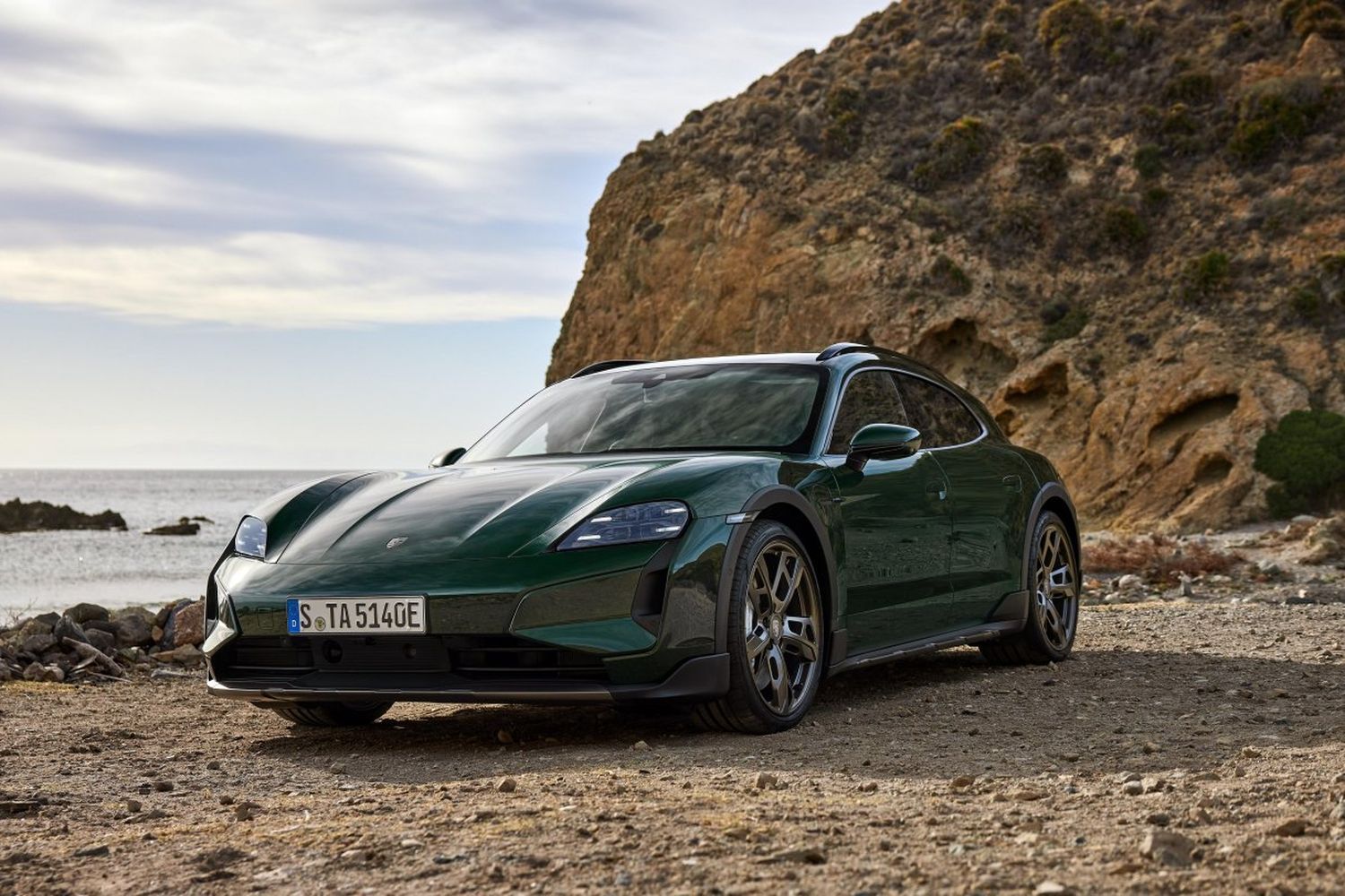Close-up of the new Porsche Taycan in green, parked on a beach
