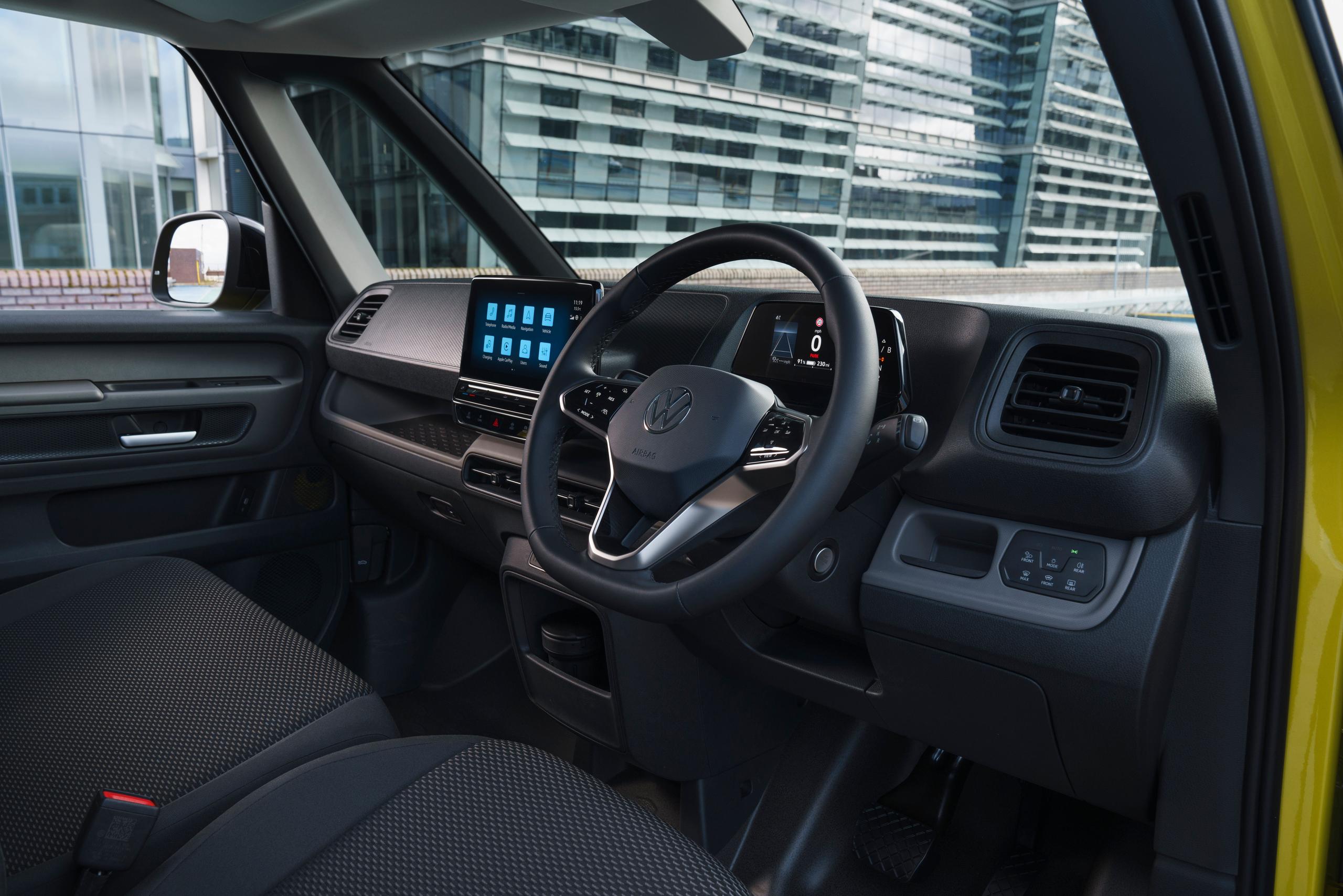 Interior view of the new Volkswagen ID.Buzz Cargo in yellow, close-up of the front passengers seats, steering wheel and central console from driver side