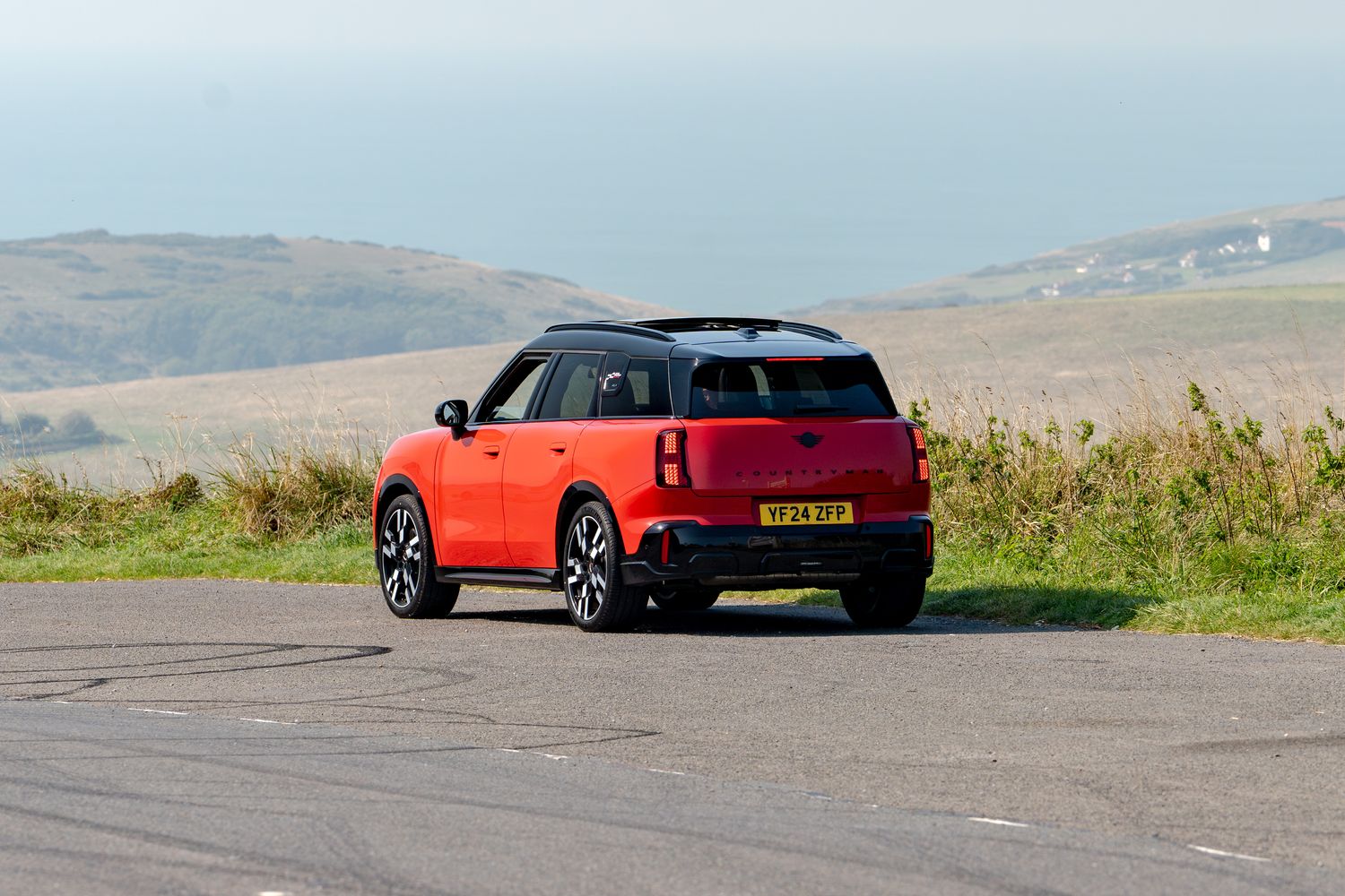 The new MINI Countryman in red, parked by the beach.