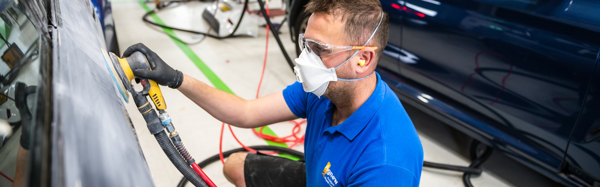 Agnew Repair Centre Specialist pre-sands the side of a damaged vehicle for preparation for filler application at the Agnew Repair Centre workshop..