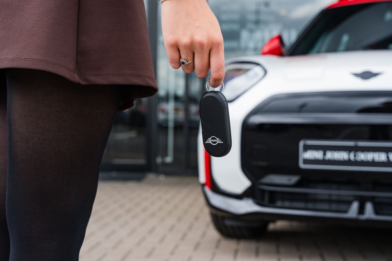 Used cars available around Northern Ireland. Customer holds key to their brand new MINI with MINI in front of them