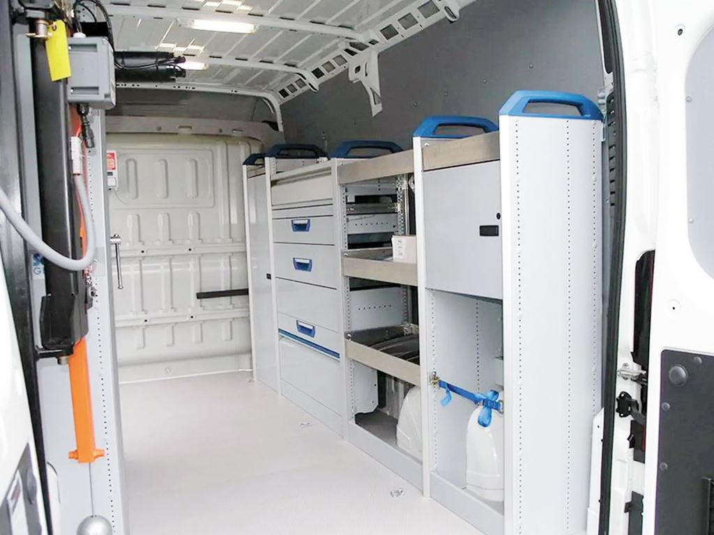 Van conversion with modular racking, storage drawers and shelving along the side wall.