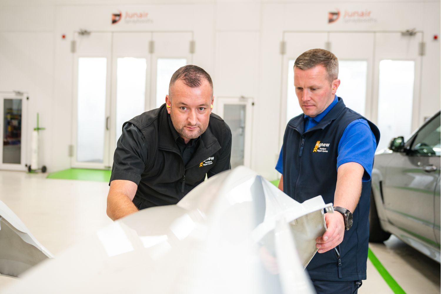 Two Agnew Repair Centre Specialist Technicians inspect electric vehicle for repair.