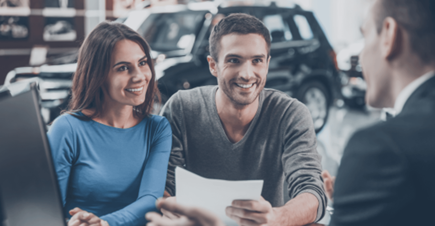 Couple smiling in a car showroom