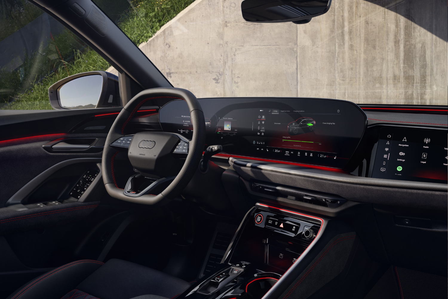 Close up of the new Audi Q5 Sportback e-hybrid's driver display and black interior with red accent lighting.