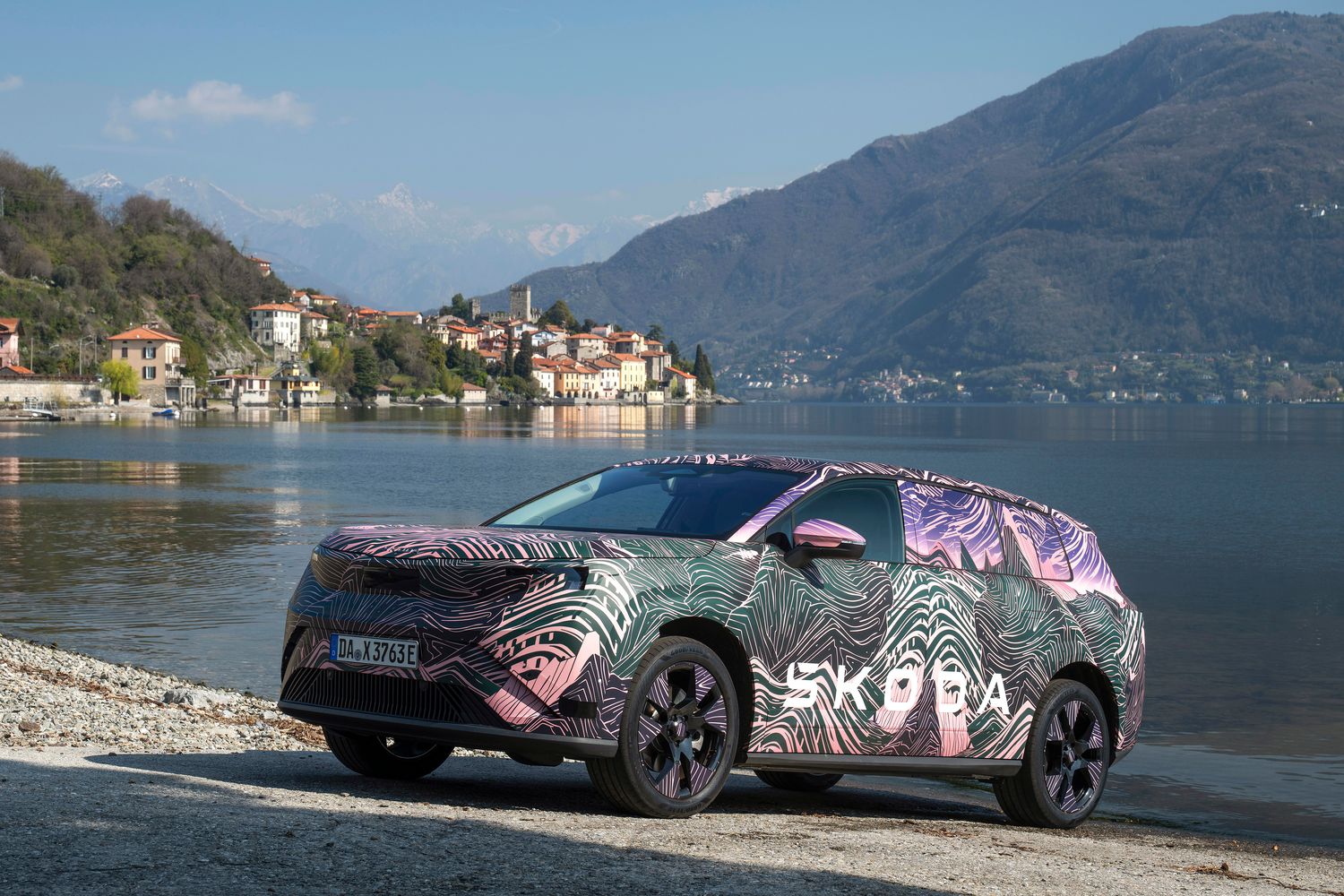 Side view of the new Skoda Peaq, parked by lake in european town.