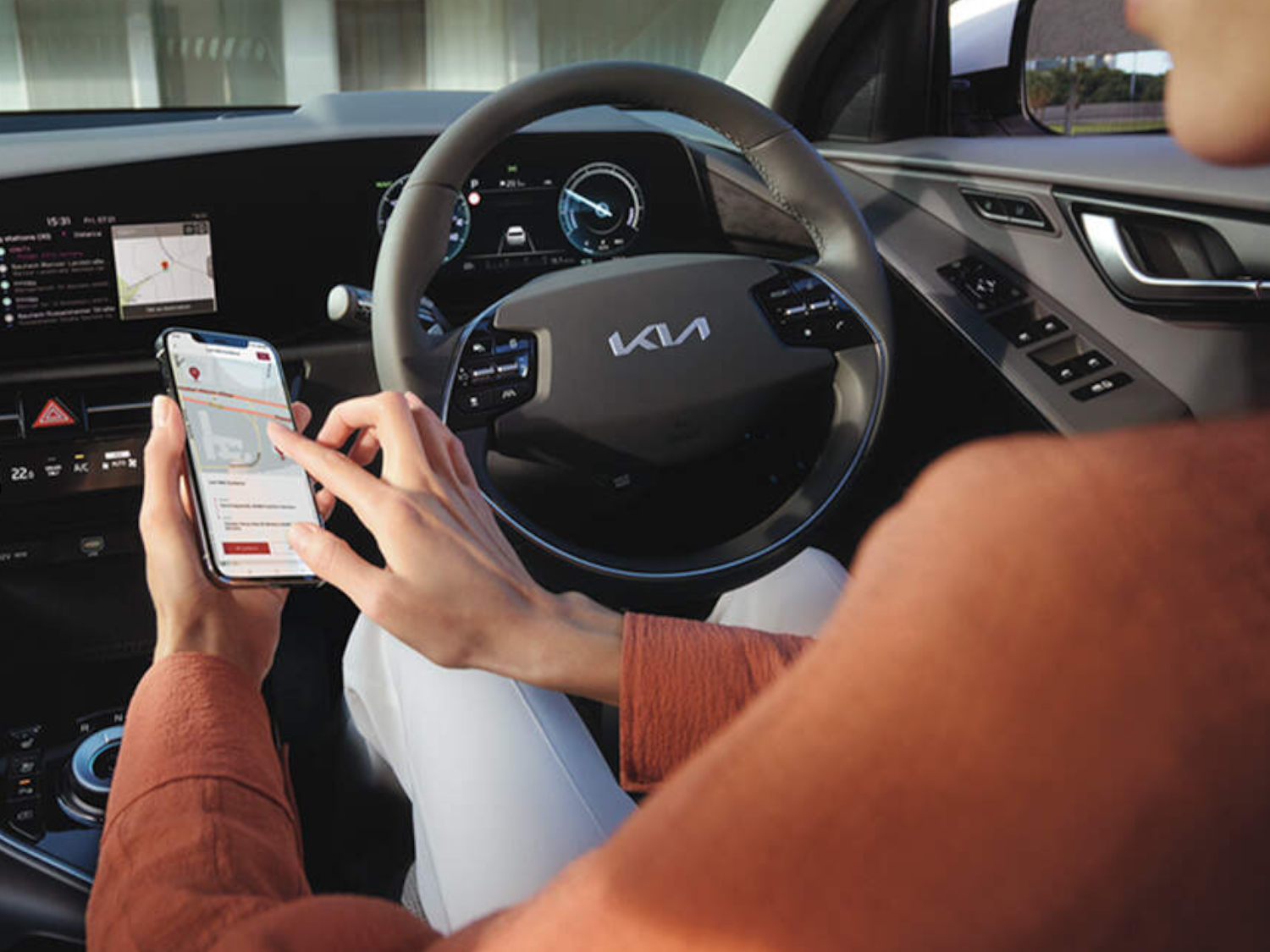 women operating phone inside Kia Niro EV