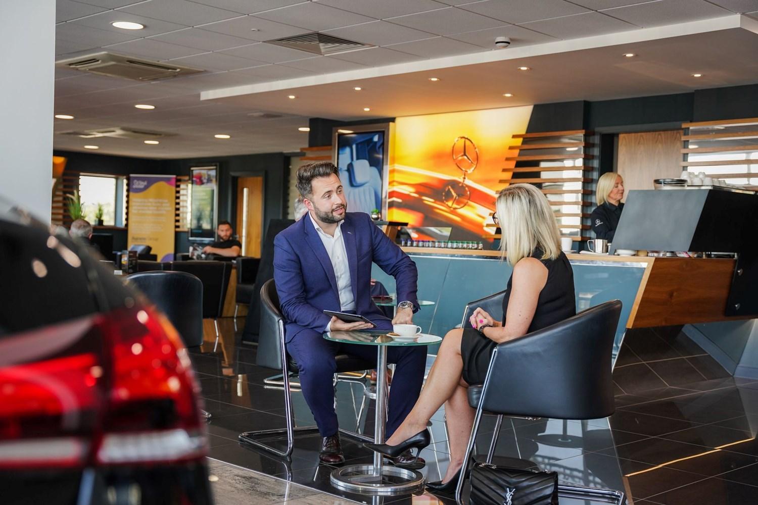 Mercedes-Benz Finance Specialist talks to customer in the Mercedes-Benz of Portadown showroom about Extended Warranty options available