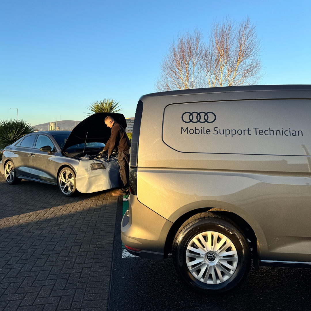 An Audi Mobile support technician performing a service on a customers vehicle.