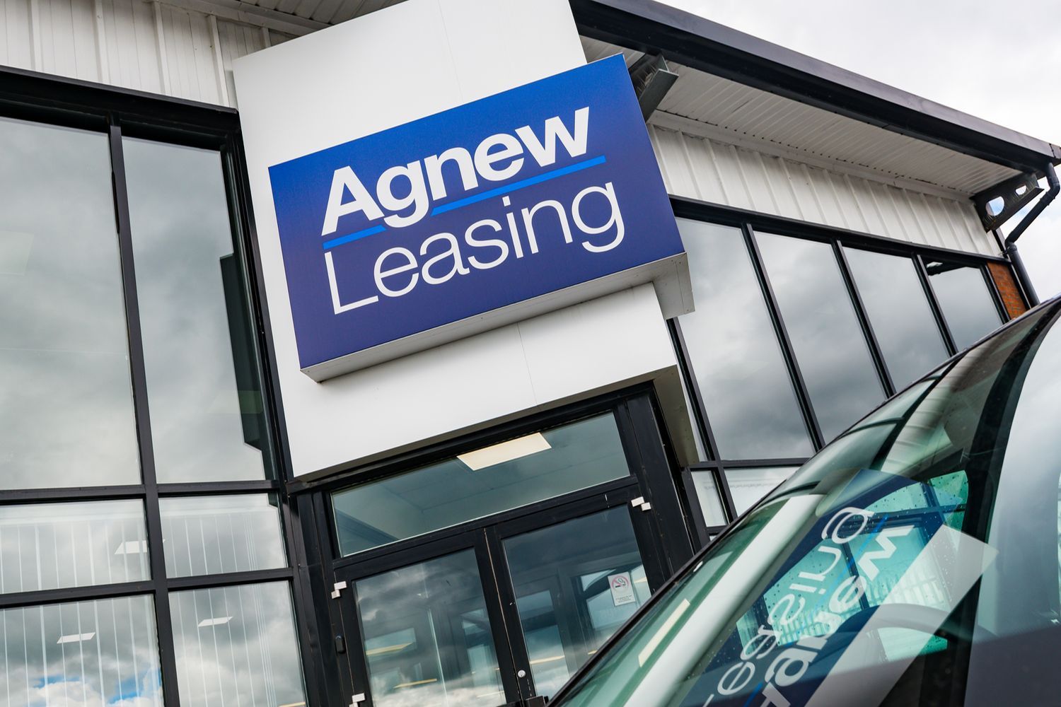 Blue and white Agnew Leasing sign outside the front of the building.