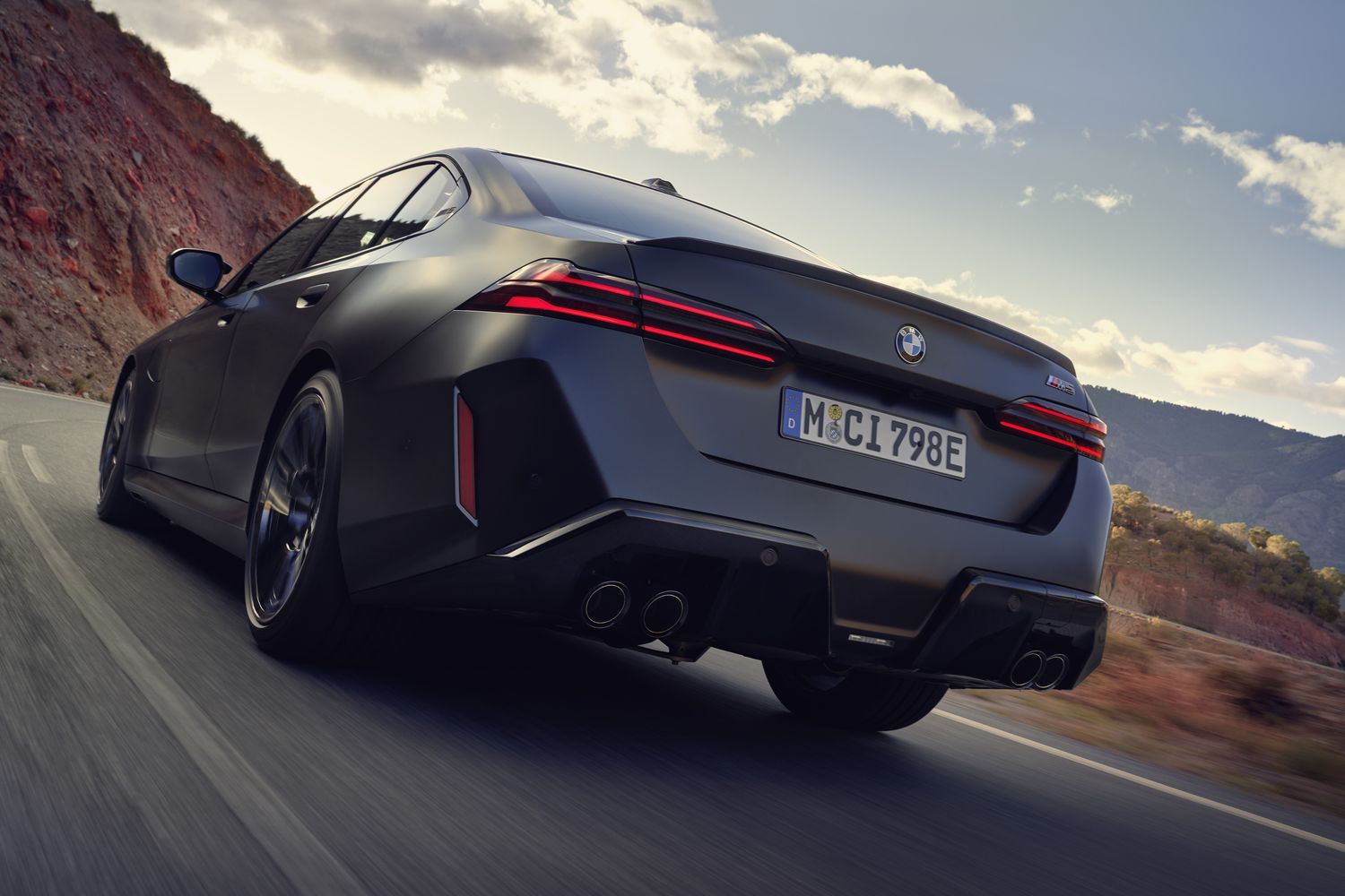 Exterior of the new BMW M5 Touring, driving on country road.