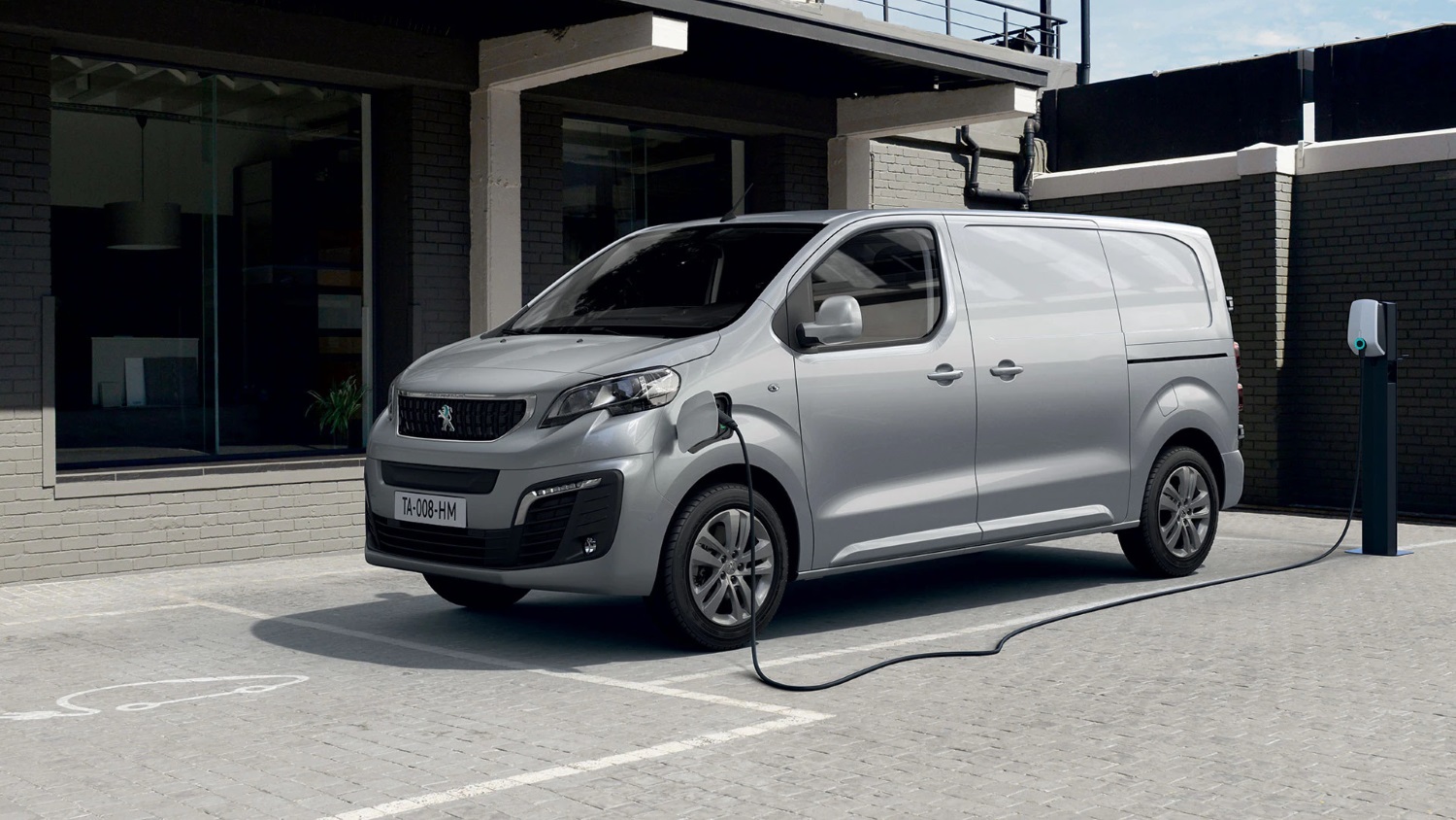 Silver Peugeot e-Expert plugged in and parked