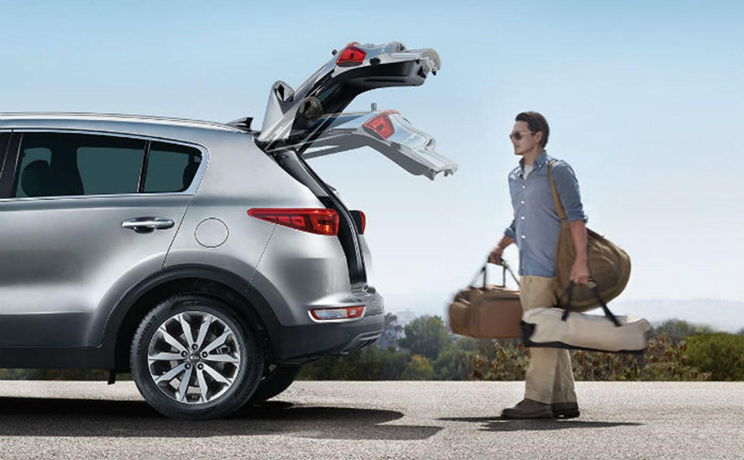 A man using the Kia liftgate feature to open the boot of his car