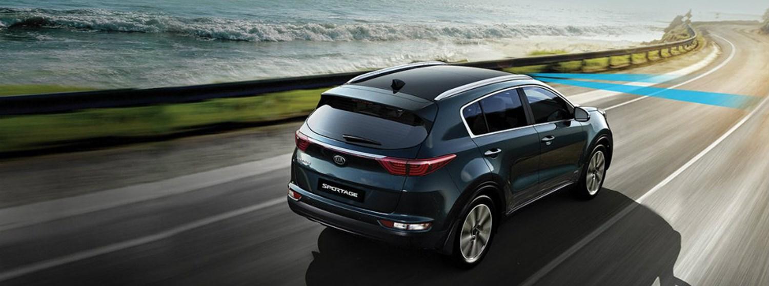A Kia Sportage driving outdoors highlighting the Lane Keep Assist feature