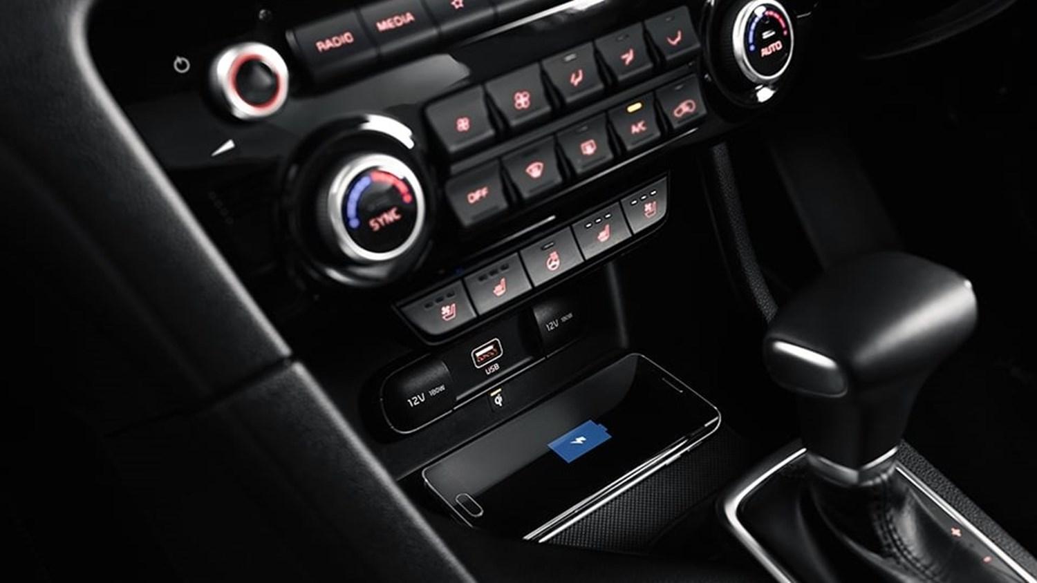 Cropped interior view showcasing the wireless charging feature in a Kia Sportage