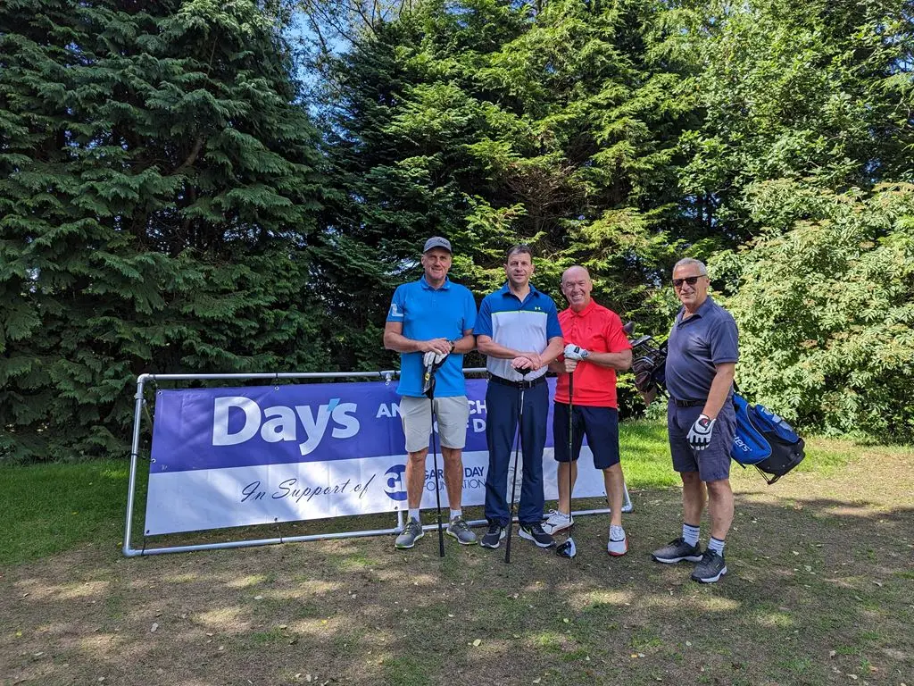 4 Men stood in front of Day's Annual Charity Golf Day banner