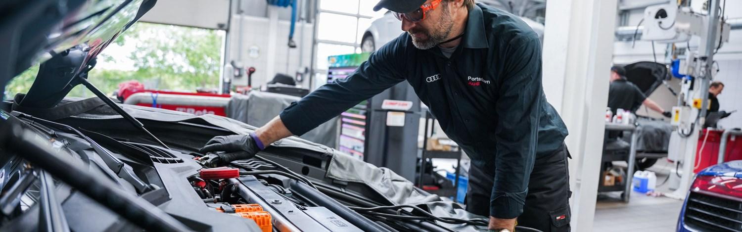 Audi Repair Specialist inspects under the hood of car during routine maintenance at the Audi Repair Centre at Portadown Audi