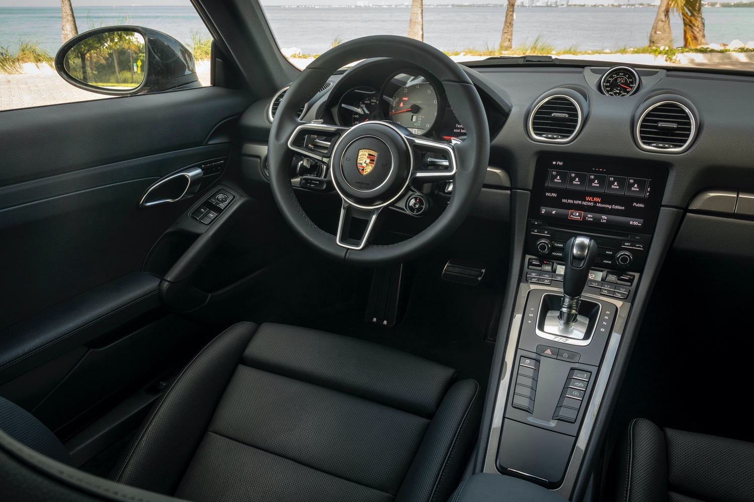 Interior view of the new Porsche 718, close-up of the steering wheel and infotainment system.