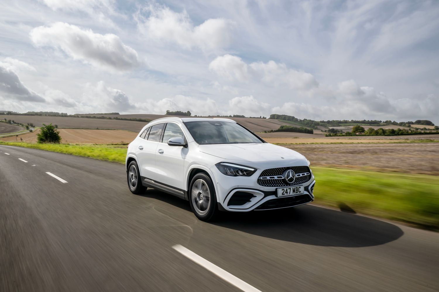 A white Mercedes-Benz GLA driving on a country road/