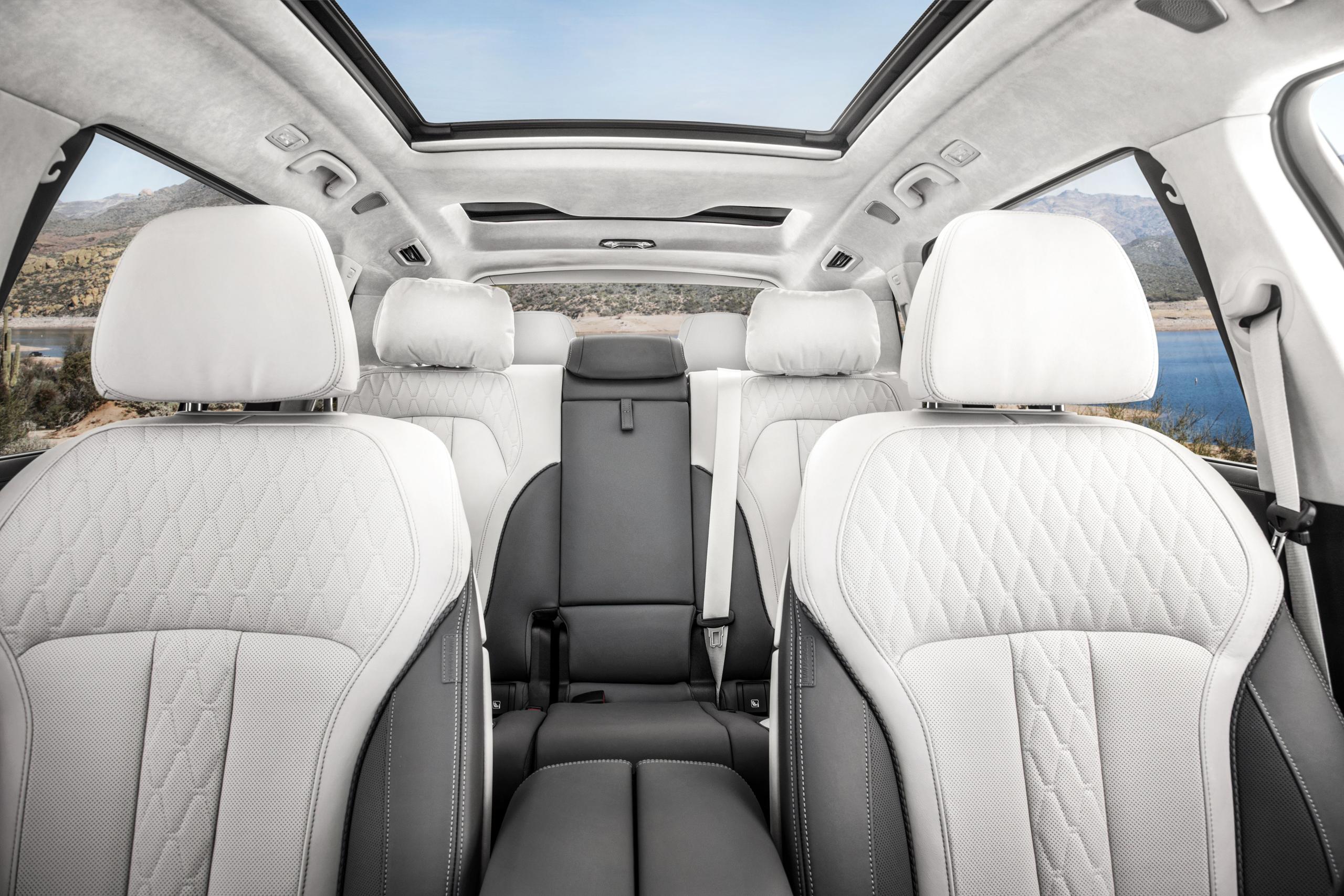 Interior view of new BMW X7, close-up of front and rear passenger seats with white and grey detailing