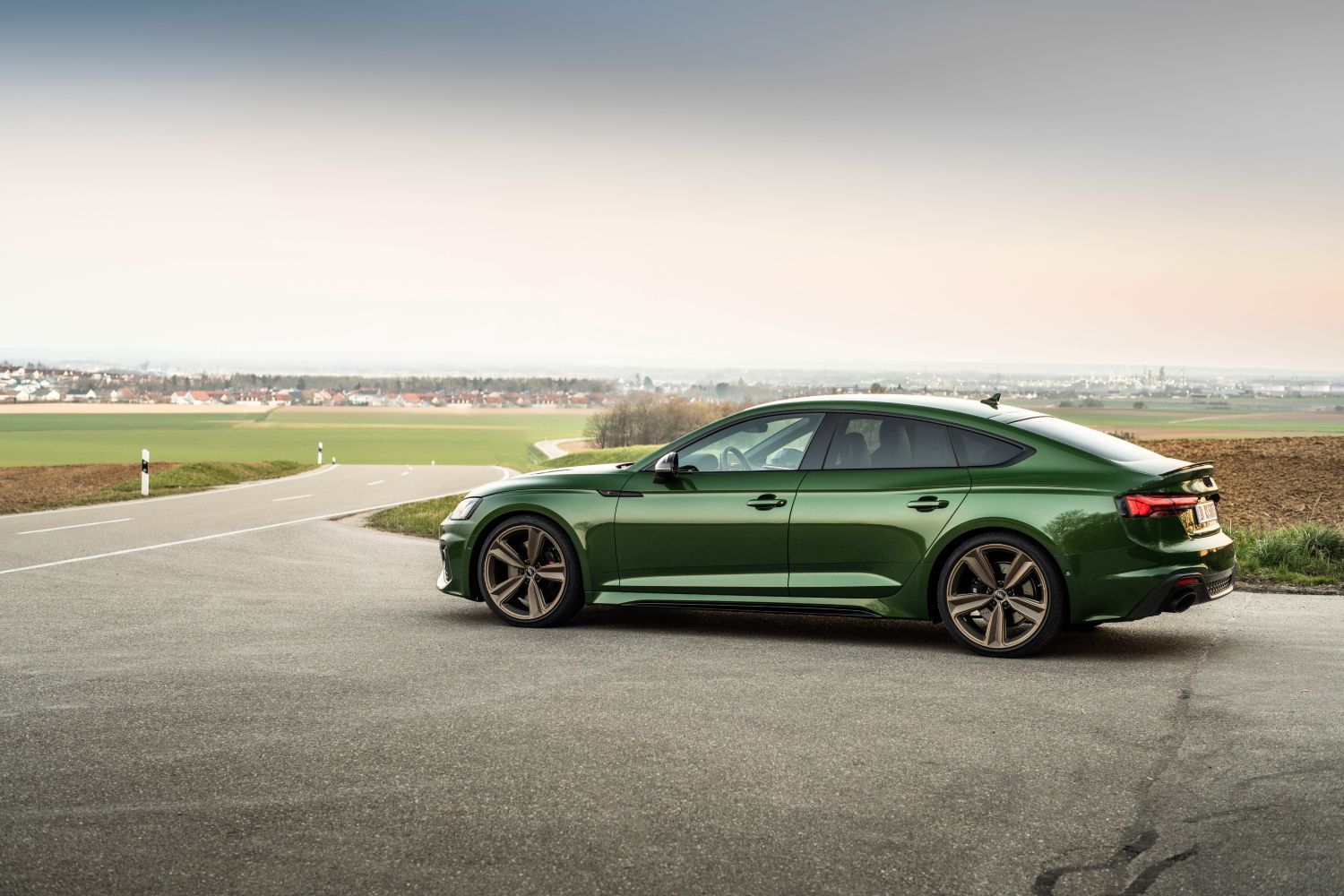 New Audi RS5 Sportback in green with sporty gold alloys parked
