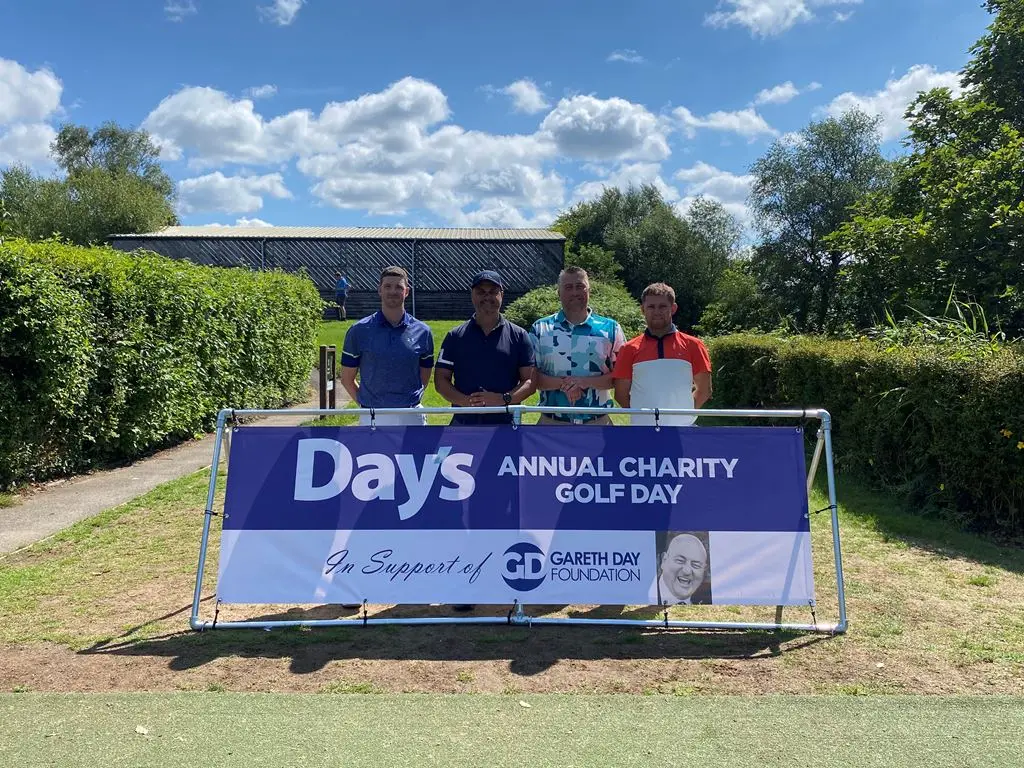 4 Men stood in front of Day's Annual Charity Golf Day banner