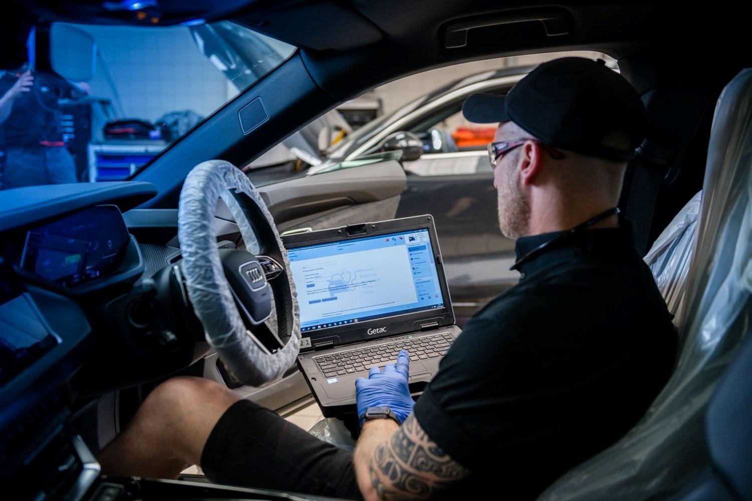 Audi Technican inspects laptop during initial diagnostic scan of vehicle at Belfast Audi