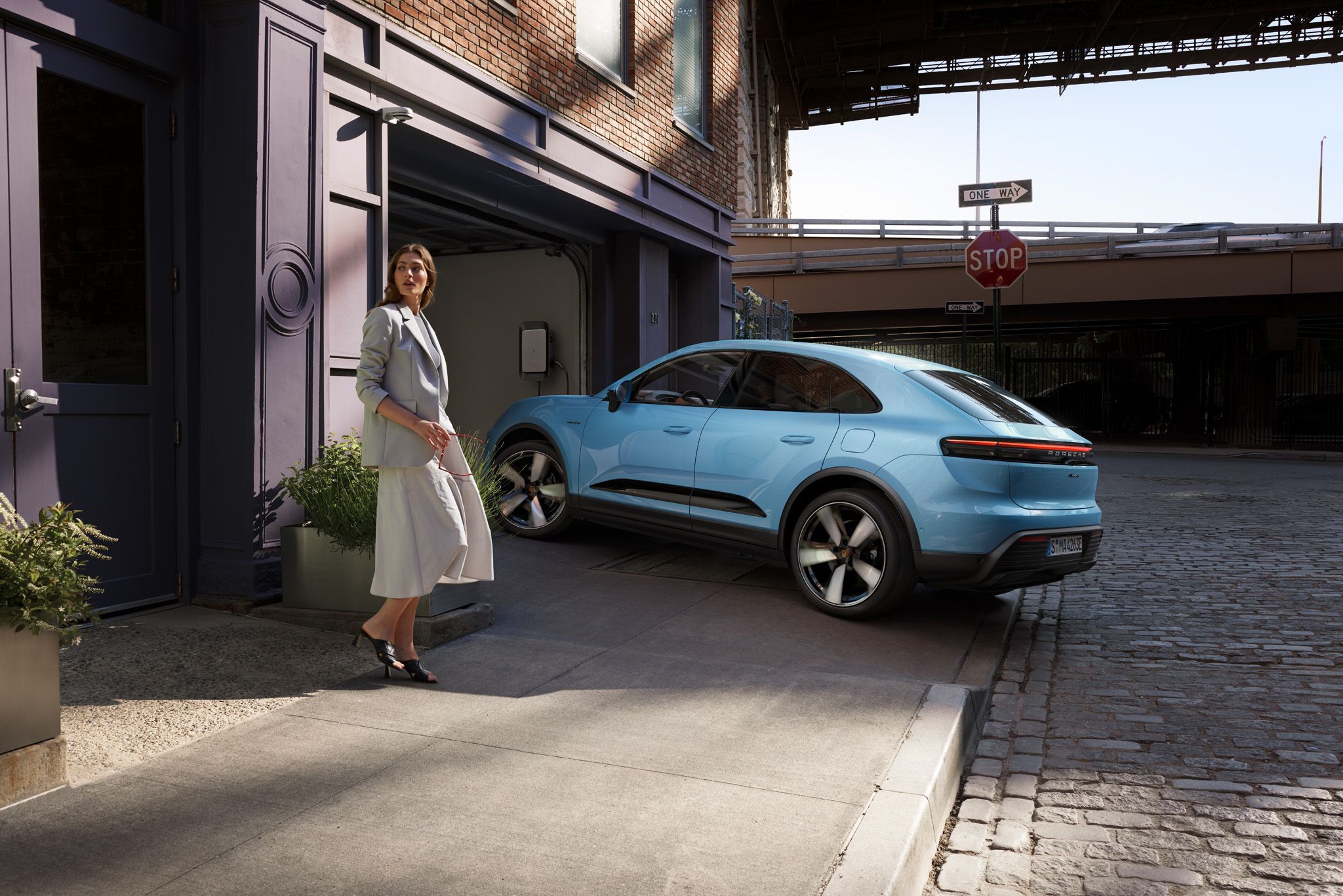 Porsche Macan Electric parked in garage and connected to an electric charging station