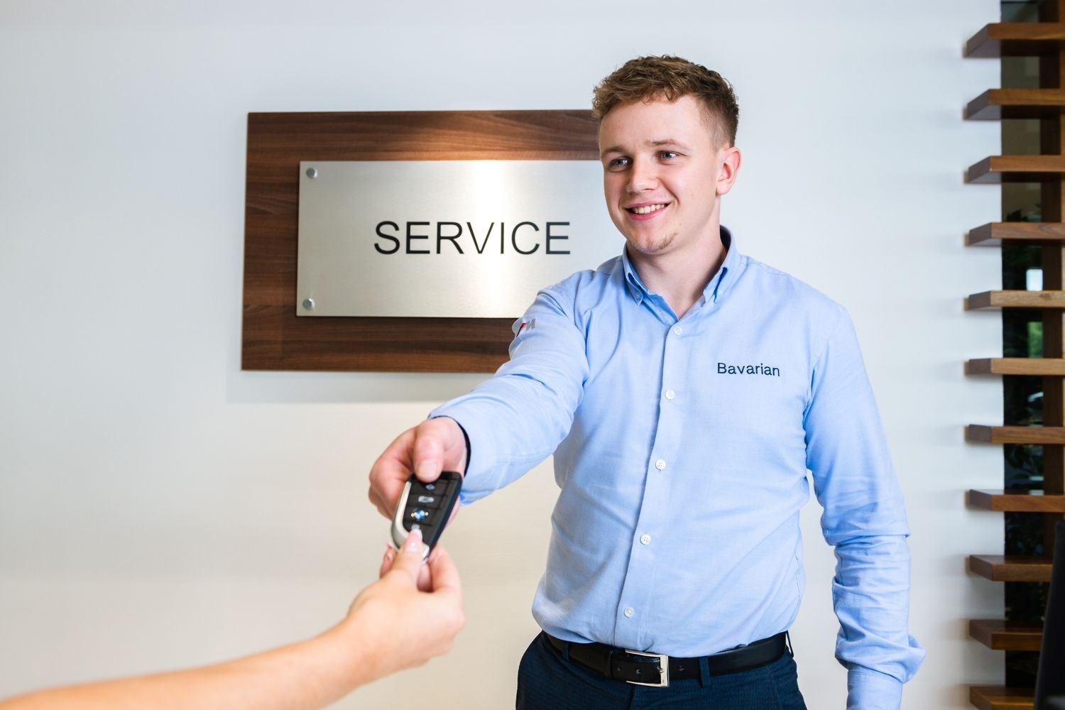 BMW Service Specialist hands over keys to happy customer after successful service at Bavarian BMW Belfast