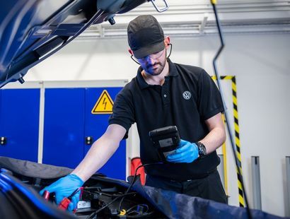 Volkswagen Service Specialist inspects Volkswagen Golf battery during pre-MOT inspection at the Volkswagen Approved Accident Repair Centre, Agnew Volkswagen Mallusk