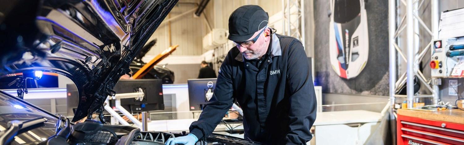 BMW Technician checks under the hood of vehicle during service at Bavarian BMW Belfast