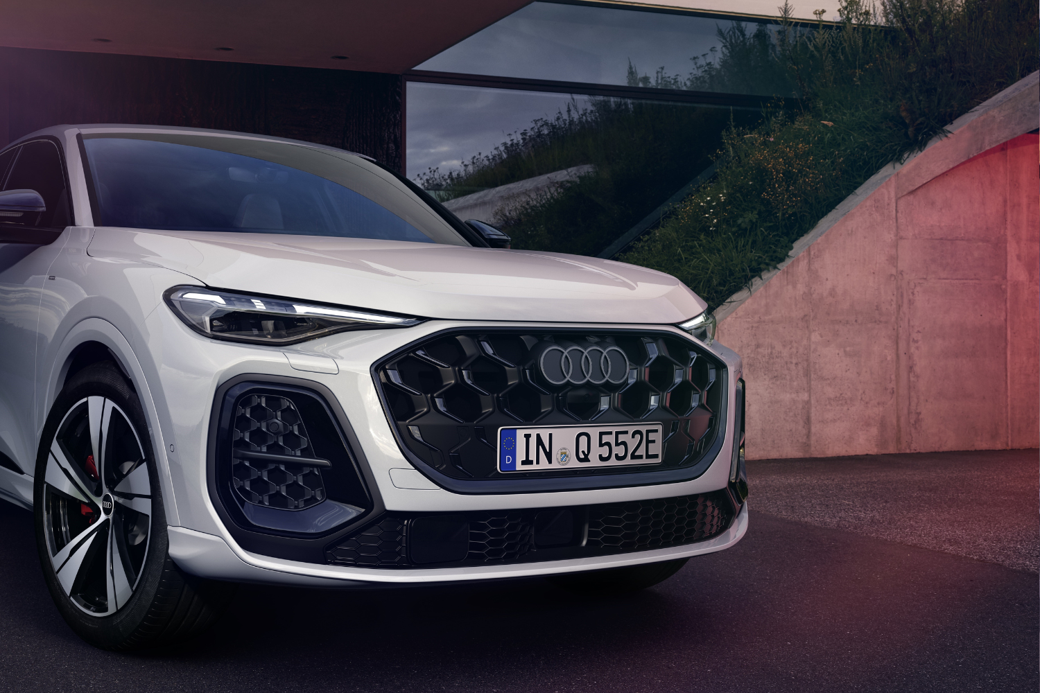 Close up front view of the new Audi Q5 Sportback e-hybrid in glacier white.