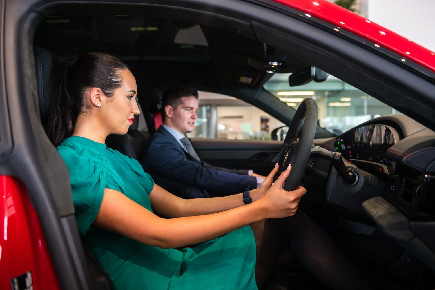 Porsche Sales Advisor highlights the key interior features of the new Porsche Panamera whilst sitting inside the vehicle with the customer at Porsche Centre Belfast