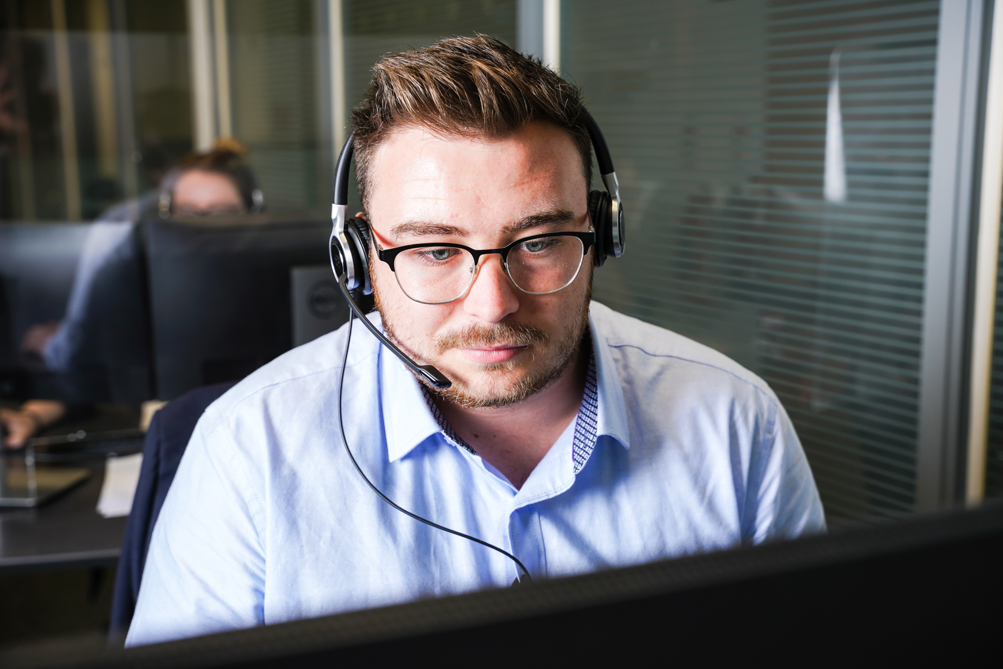 MINI Customer Service Specialist chats to customer through a computer while using a headset