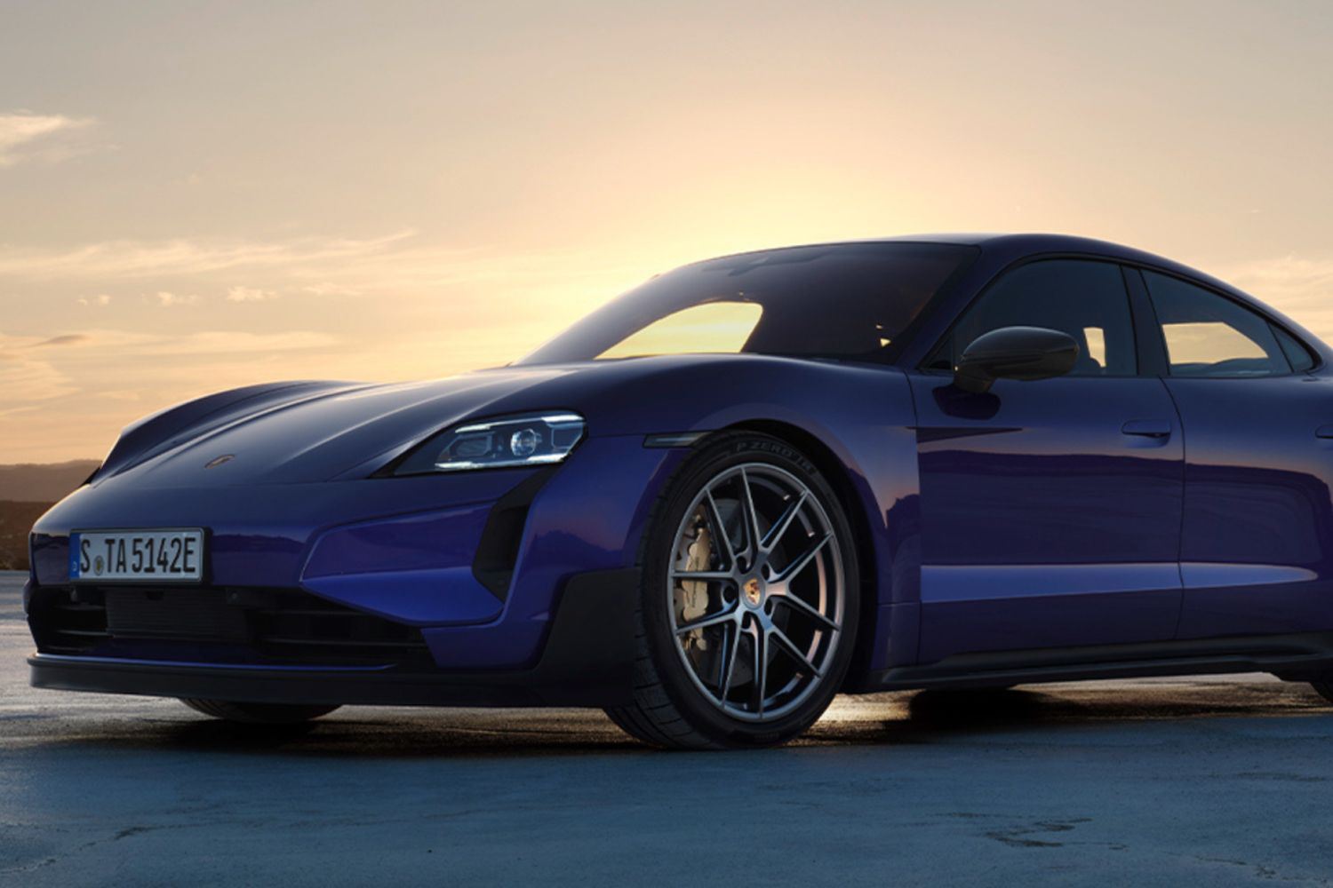 Front view close-up of the Porsche Taycan Turbo GT (in purple) with Weissach Package at sunrise, parked on main road.