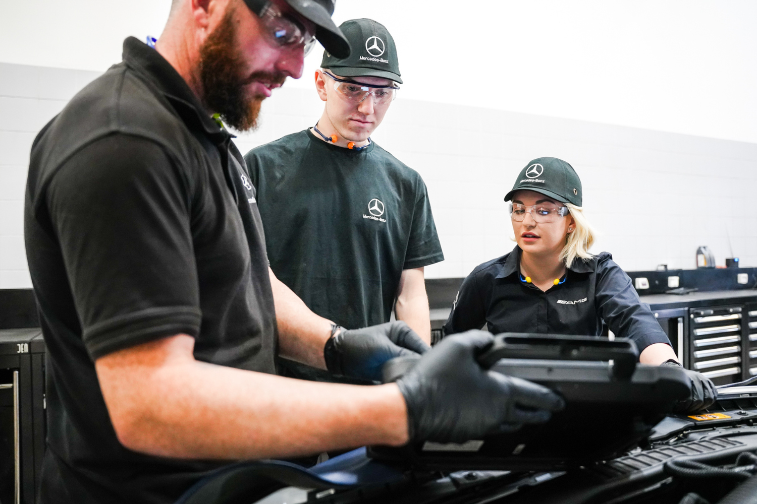 Three Mercedes-Benz Technicians inspect vehicle during Premium Servicing work